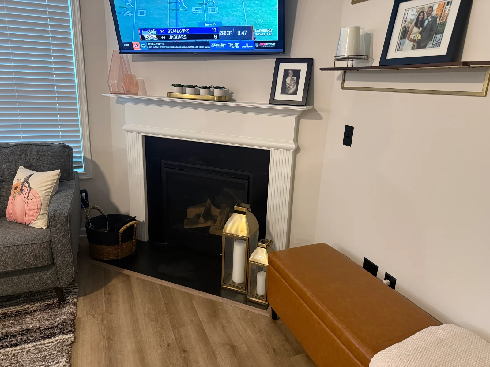 White fireplace surround with black insert, floating shelves, and luxury vinyl plank flooring in living room